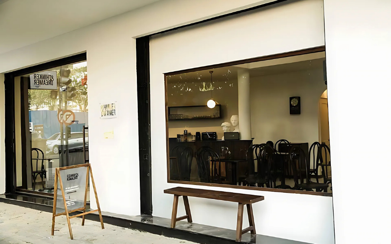 Quán cafe mặt tiền 7m đậm chất Industrial với biển hiệu chữ đen trên nền gỗ nâu mộc mạc, tạo điểm nhấn cá tính