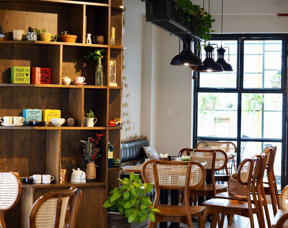 Trang trí trong quán cafe Tân cổ điển dưới 50m² nên tinh giản nhưng tinh tế, tập trung vào tranh tường và đèn decor ánh vàng