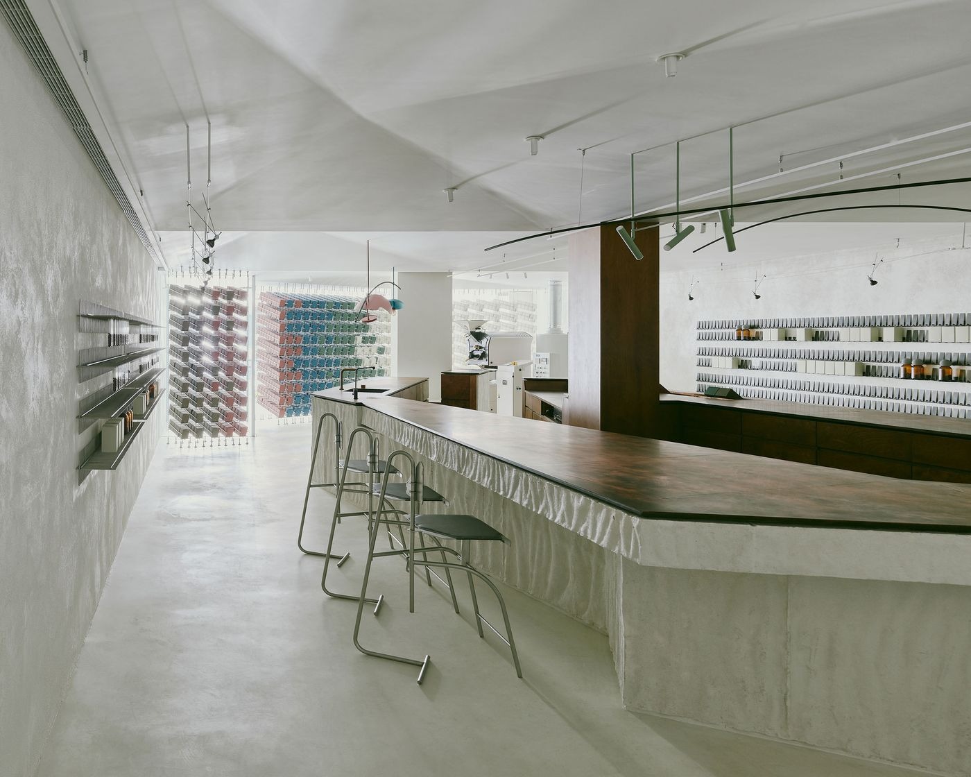Quầy bar trong quán cafe Minimalism thường có thiết kế dạng khối đơn giản, sử dụng vật liệu mộc mạc như bê tông mài, gỗ trơn hoặc đá