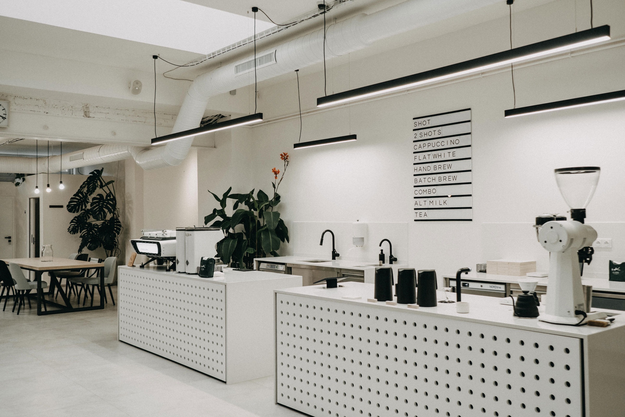 Trang trí trong quán cafe Minimalism thường tối giản đến mức tinh tế: chỉ sử dụng một vài tranh treo tường, chậu cây xanh nhỏ hoặc đèn decor làm điểm nhấn