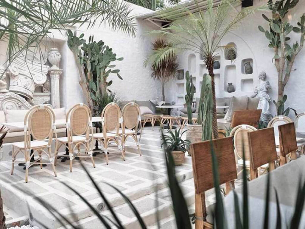 Lối kiến trúc kết hợp xương rồng, bàn ghế gỗ và mây đan tạo nên không gian tropical mộc mạc, phóng khoáng và tràn đầy sức sống trong thiết kế quán cafe 3 tầng