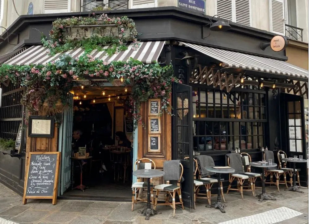 Mặt tiền quán cafe góc phố nổi bật với phong cách Vintage gam màu đen sang trọng, kết hợp mảng kính lớn và cây xanh tạo cảm giác hiện đại, tinh tế nhưng vẫn gần gũi