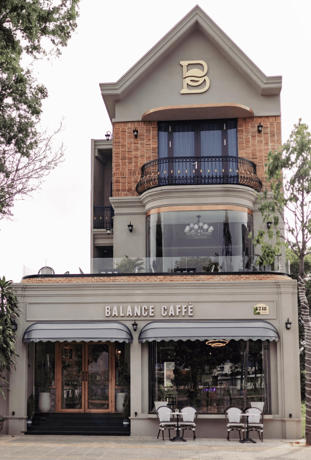 Thiết kế quán cafe 3 tầng phong cách châu Âu thường nổi bật với mái vòm, ban công sắt uốn, hệ cửa lớn đối xứng và mặt tiền mang đậm nét cổ điển sang trọng