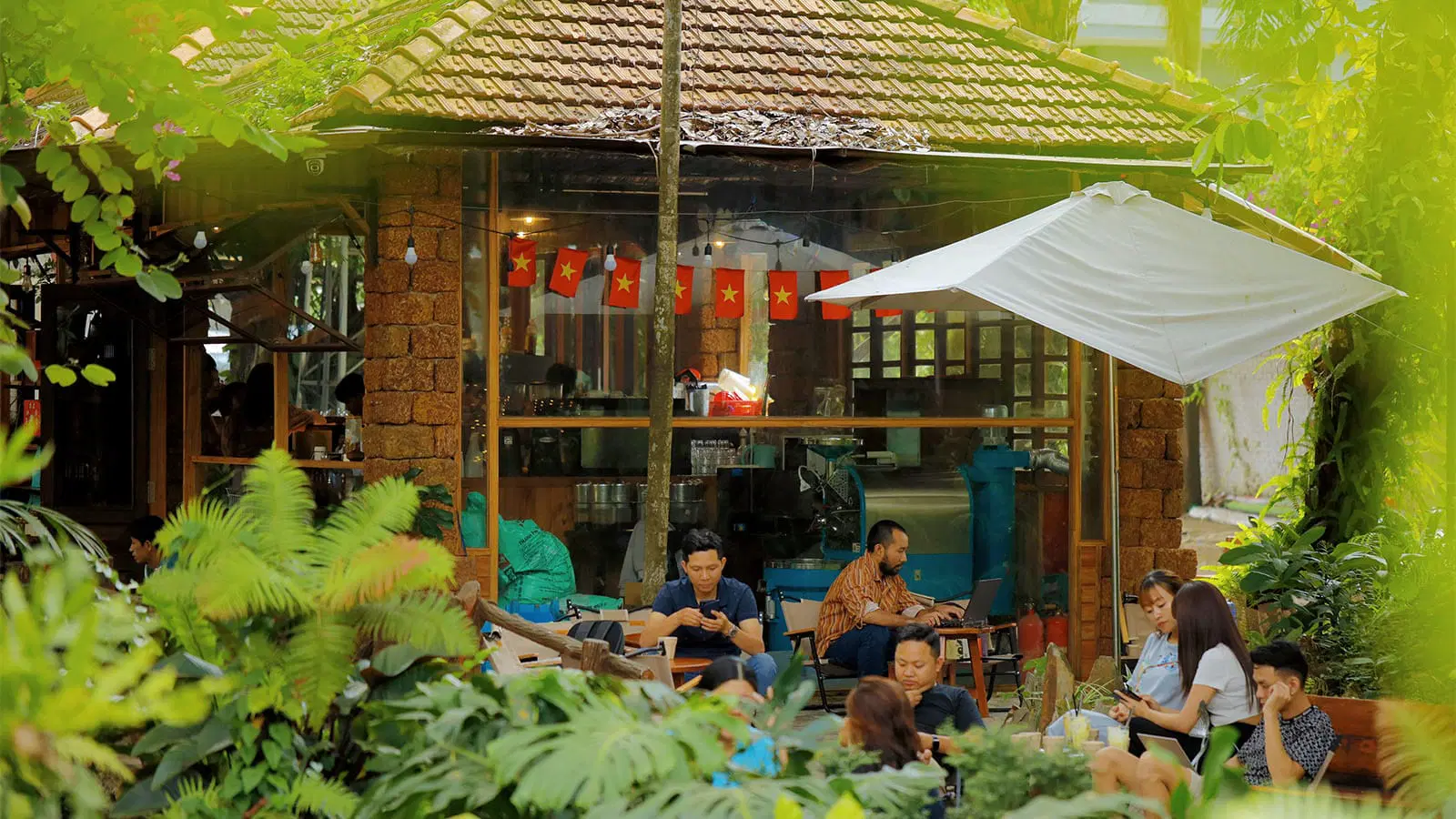 Quán cà phê sân vườn với mái ngói đỏ rêu phong, khu vườn xanh mát và lá cờ đỏ sao vàng bay phấp phới mang đậm hồn Việt giữa lòng phố thị