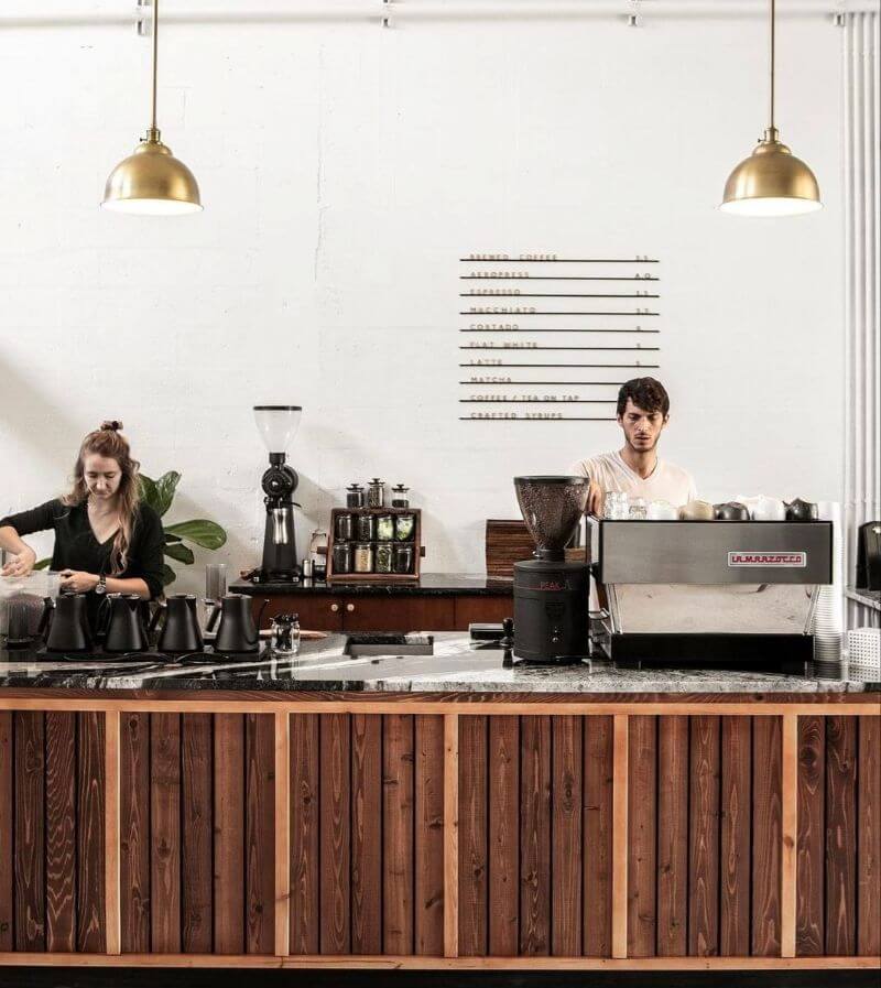 Thiết kế quầy bar nổi bật với các thanh gỗ sọc dọc, vân gỗ rõ nét cùng những mắt gỗ nhỏ tạo điểm nhấn tự nhiên và sống động  