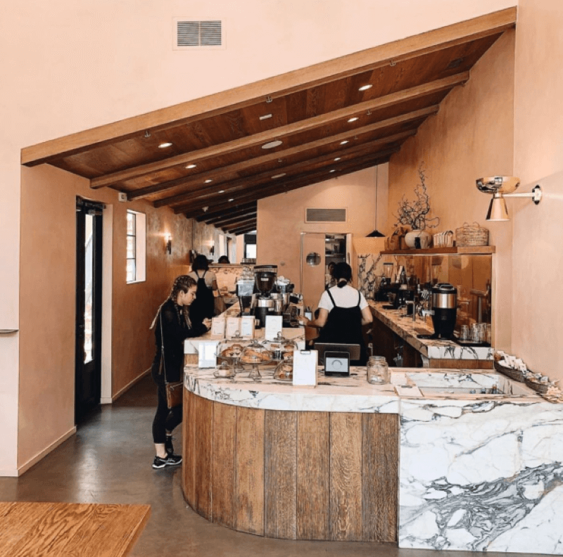 Thiết kế quầy bar với họa tiết vân gỗ rõ nét, các thanh gỗ xếp dọc liền kề nhau tạo hiệu ứng thị giác kéo dài, mang đến cảm giác hiện đại và tinh tế cho không gian  