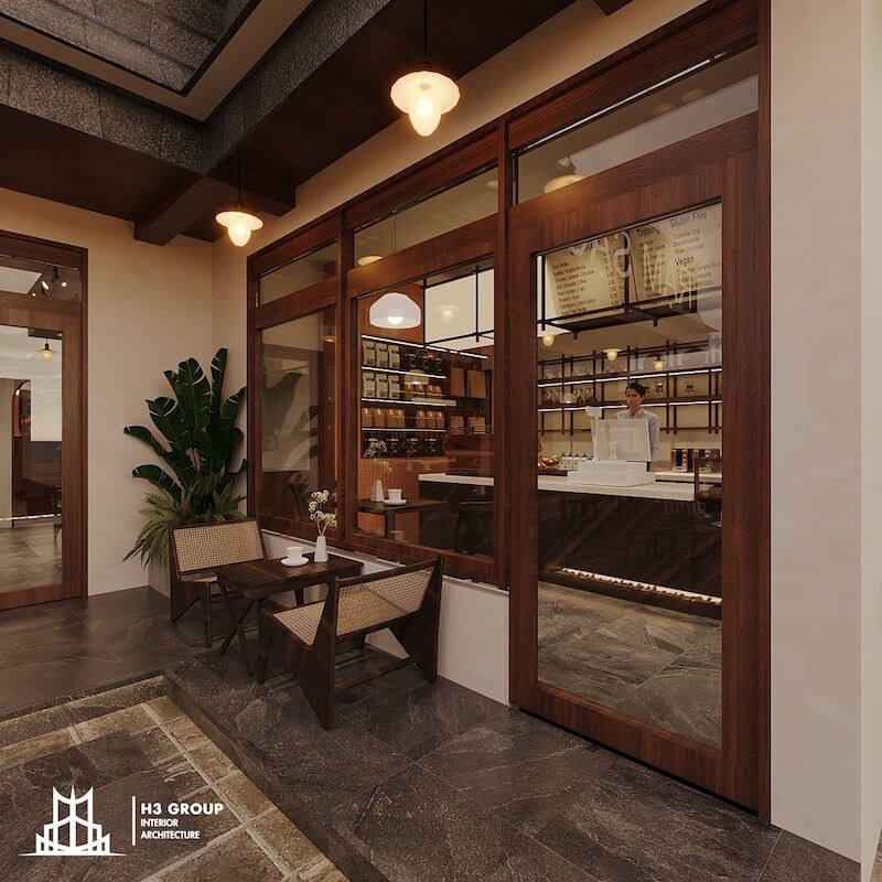 Quán cà phê phong cách Rustic với mặt tiền gỗ ấm áp, cửa kính lớn hé lộ không gian bên trong và khu vực ngồi ngoài trời nhỏ xinh,