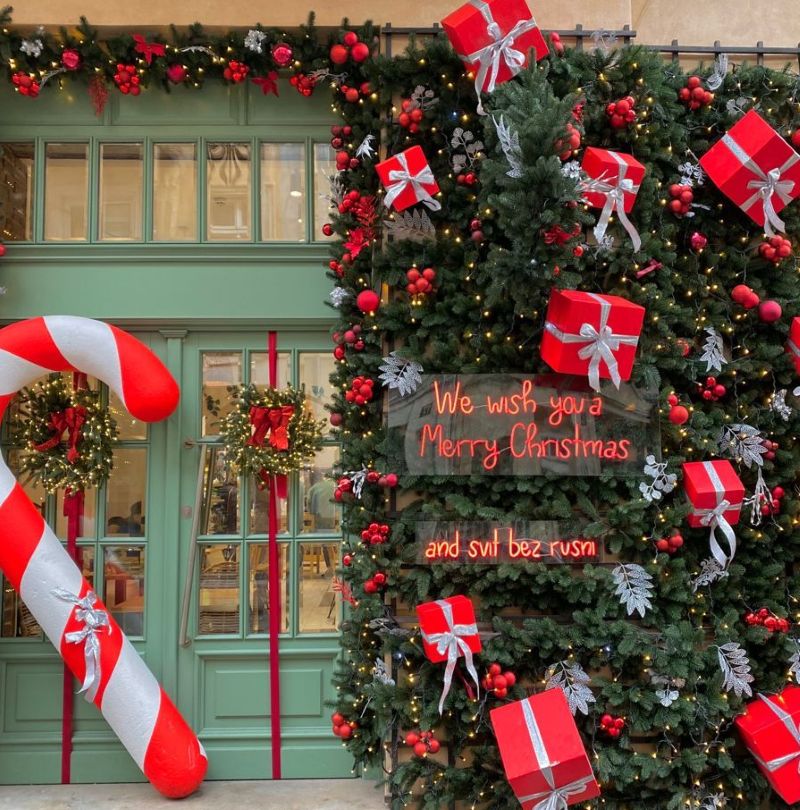 Mặt tiền quán cafe được trang trí Giáng Sinh với cây thông, hộp quà, gậy kẹo khổng lồ và dòng chữ phát sáng “We wish you a Merry Christmas” thu hút sự chú ý của khách hàng 