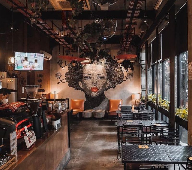 Quán cà phê được trang trí bằng một bức vẽ lớn ngay trung tâm, trở thành điểm nhấn thị giác mạnh mẽ và tạo dấu ấn riêng cho không gian 