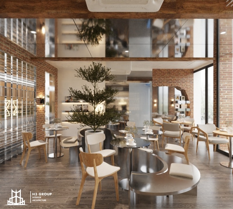Quán cafe mang đậm phong cách Industrial với tường gạch thô, trần cao và hệ thống đèn thả cá tính. Nội thất gỗ và kim loại kết hợp cùng cây xanh tạo nên một không gian vừa mạnh mẽ vừa ấm cúng