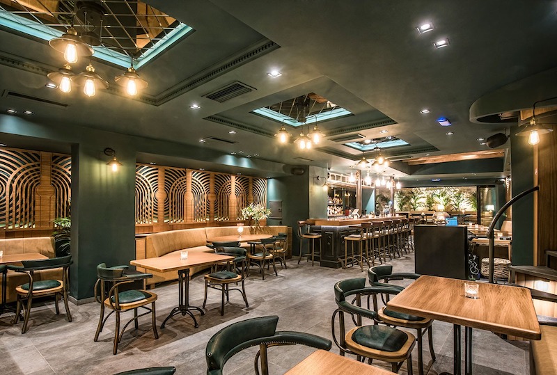 Mẫu quán cafe phong cách Retro sử dụng đèn vàng và hoa văn trang trí tường tạo nên một không gian vừa hoài niệm vừa ấm áp