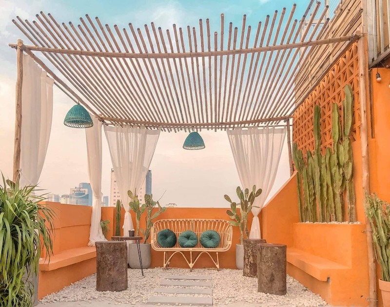 Quán cafe sân thượng phong cách Bohemian với sự kết hợp của đồ mây tre, gối nhiều màu và họa tiết thổ cẩm tạo nên một bức tranh sống động