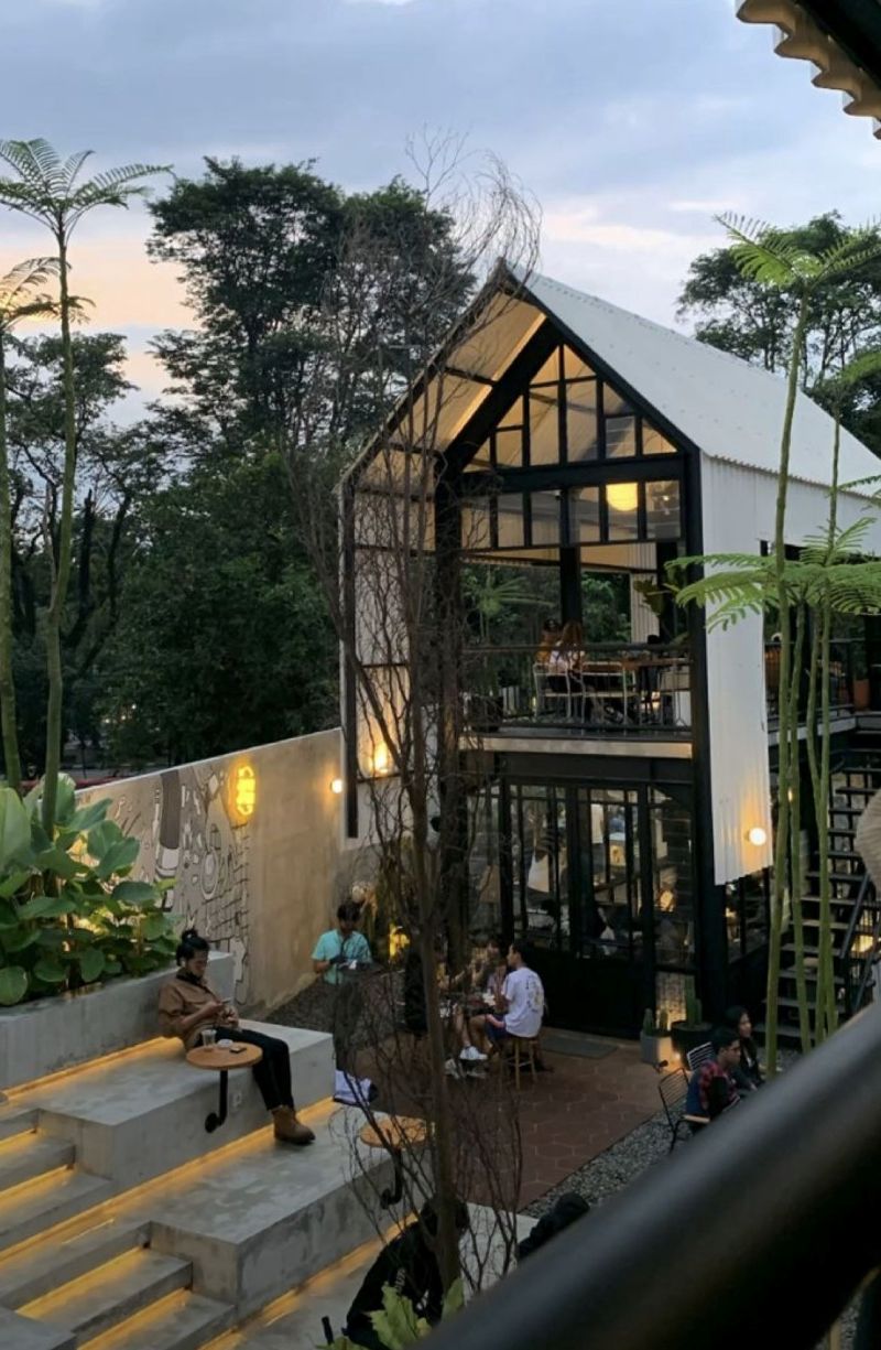 Quán cafe khung thép 2 tầng phong cách Tropical tạo cảm giác gần gũi thiên nhiên với cây xanh được bố trí xuyên tầng và bao quanh không gian 