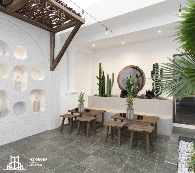 Tận dụng không gian sân vườn rộng 100m2, quán cà phê được thiết kế với tường trắng, nội thất gỗ mộc cùng cây xanh tạo cảm giác gần gũi và thư thái như một ốc đảo giữa lòng thành phố