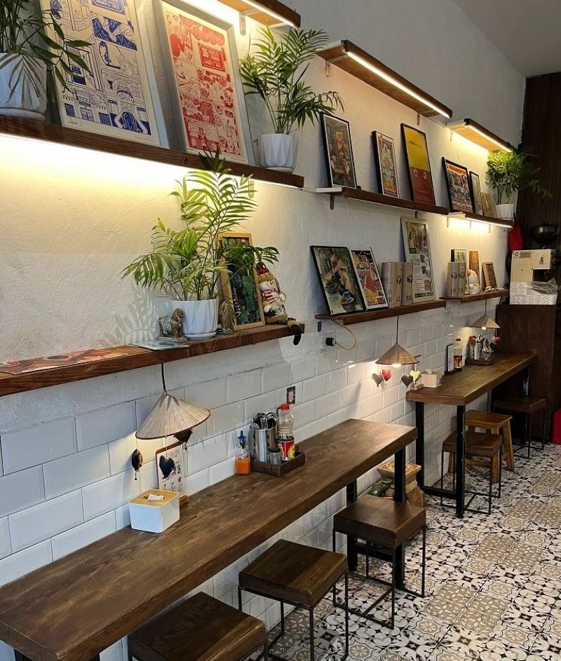 Sử dụng kệ gỗ làm decor giúp quán thể hiện gu thẩm mỹ riêng và tạo ấn tượng với khách hàng