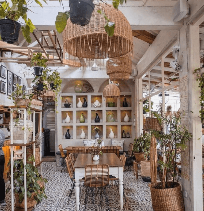 Không gian nổi bật với trần nhà cao, nhiều cây xanh, nội thất mây tre đan và sàn gạch hoa văn độc đáo, tạo cảm giác gần gũi, thư giãn và đầy tính nghệ thuật.