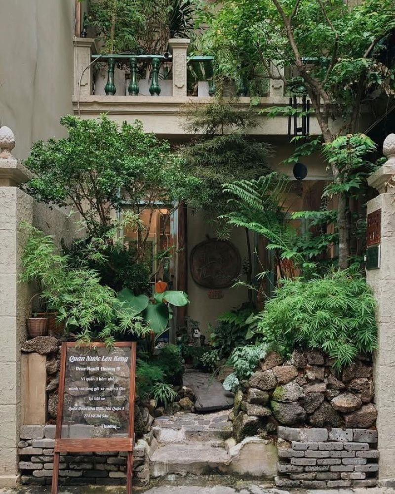 Quán cafe sân vườn nhỏ trước nhà nổi bật với những chậu cây và hoa rực rỡ