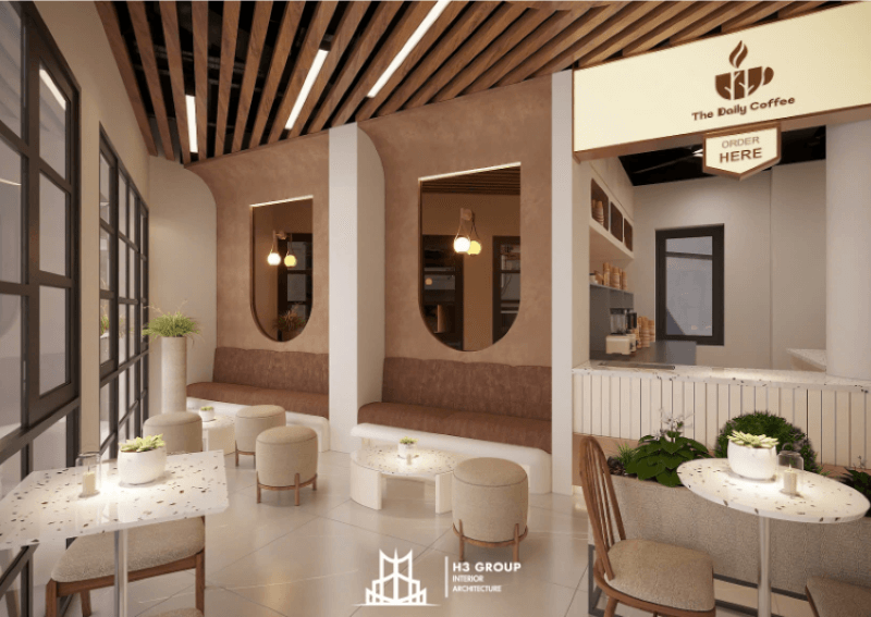 Không gian quán cà phê hiện đại và ấm cúng, nổi bật với trần gỗ độc đáo, nội thất bọc nỉ êm ái cùng tông màu be và nâu đất, tạo cảm giác thoải mái và gần gũi.