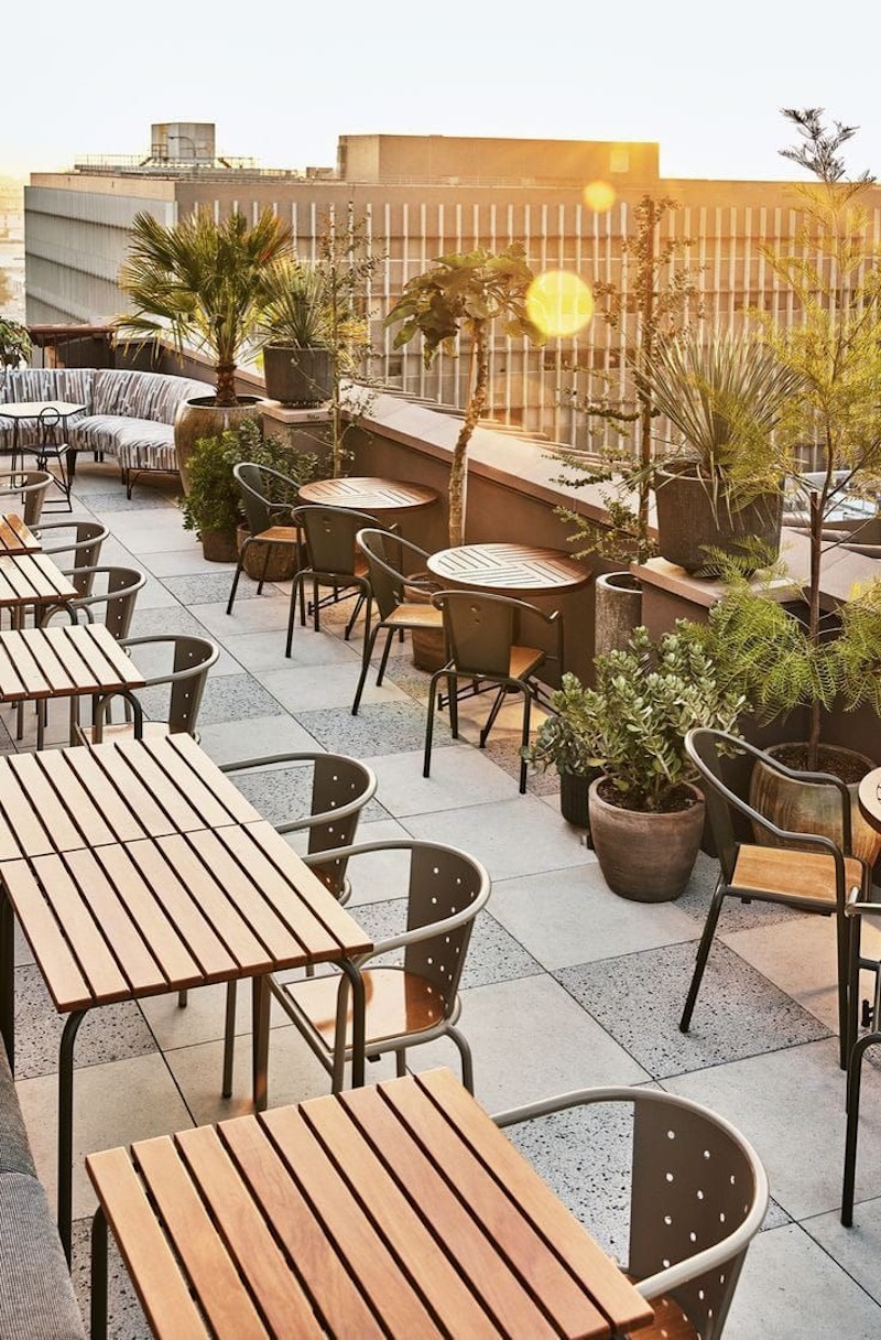 Quán cafe tối giản rooftop tận dụng ánh sáng tự nhiên vào ban ngày để giảm tiêu thụ điện năng và tăng trải nghiệm