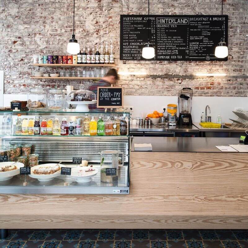 Gỗ tần bì ốp quầy bar mang tông màu be nhẹ, nổi bật với vân gỗ rõ nét dạng sóng hoặc xoáy, tạo hiệu ứng thị giác sinh động và cuốn hút  