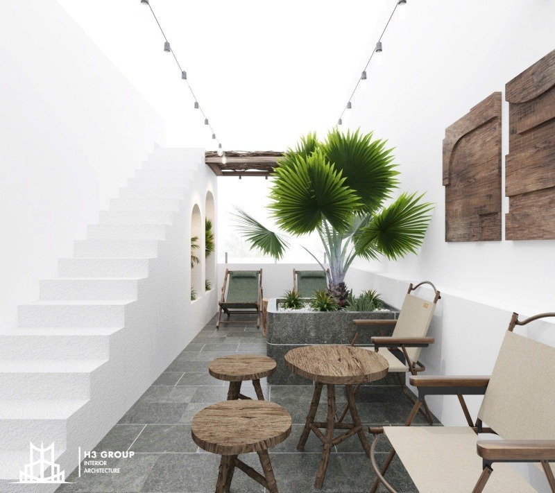 Thiết kế quán cà phê sân vườn 100m2 này tận dụng tối đa không gian mở với tường trắng, cầu thang và vòm cong, kết hợp nội thất mộc và cây xanh để tạo cảm giác dễ chịu
