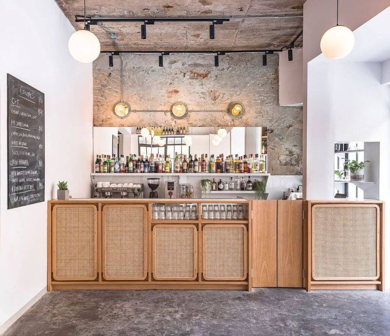 Quầy bar gỗ tần bì tạo điểm nhấn ấn tượng với phần lưới mây đan kết tinh tế, mang đến vẻ đẹp vừa mộc mạc vừa độc đáo cho không gian  