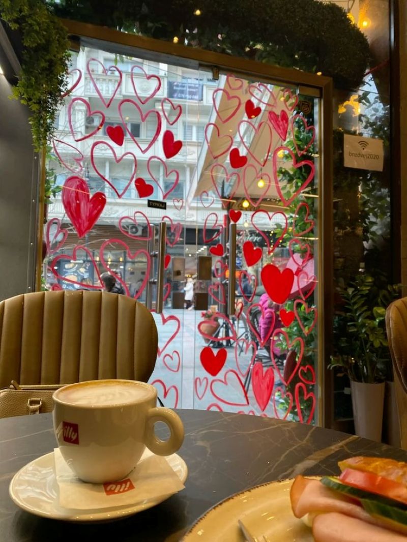 Quán cà phê được trang trí dịp Valentine với khung cửa phủ đầy những trái tim đỏ, tạo không gian lãng mạn và ấm áp cho các cặp đôi