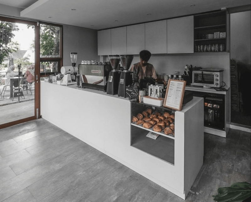 Quầy bar với mặt đá trơn nhẵn và hệ tủ âm tường tạo cảm giác liền mạch, gọn gàng