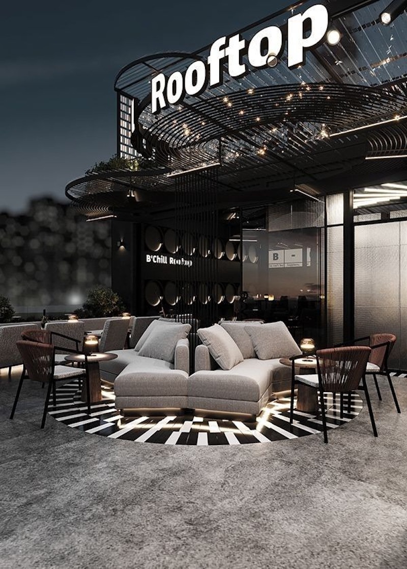 Không gian rooftop phóng khoáng với khung sắt và ánh sáng vàng, gợi cảm giác ấm áp giữa đêm thành phố