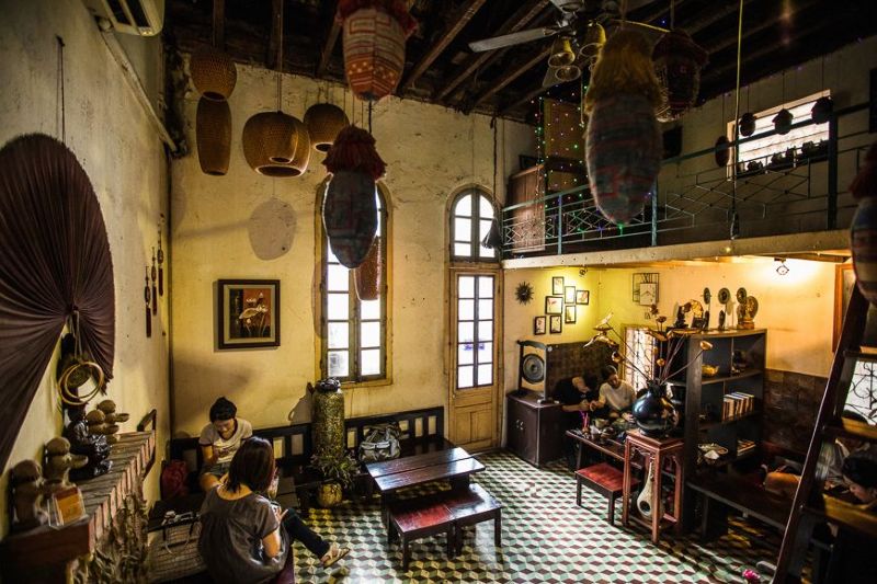 Quán cafe phong cách bao cấp thu hút với decor với bàn ghế gỗ cũ, đèn dầu, radio và không gian tường xám retro