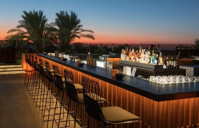 Quầy bar ngoài trời là trung tâm kết nối, nơi khách vừa thưởng thức cà phê vừa ngắm hoàng hôn