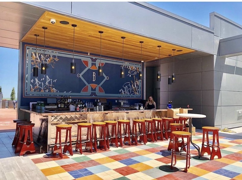 Không gian rooftop hiện đại với quầy bar được ốp đá sang trọng và đèn trang trí bắt mắt