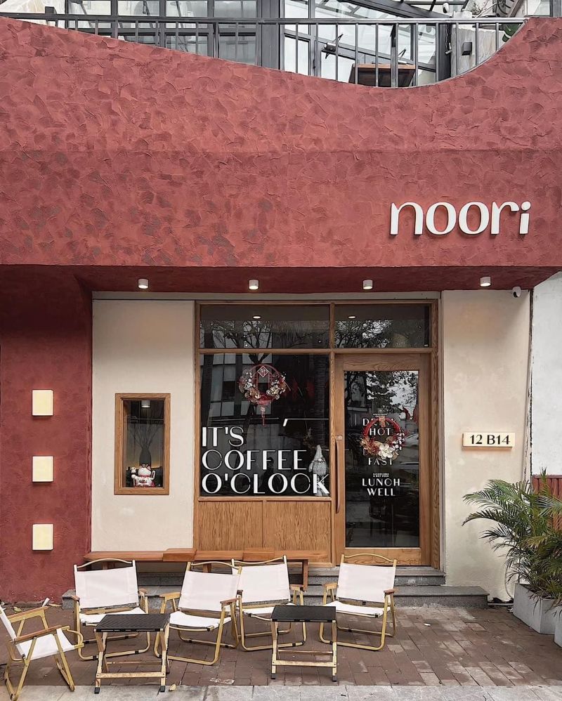 Mặt tiền quán cafe với tone đỏ đất nung (terracotta) kết hợp màu be mang đến vẻ ấm áp, gần gũi nhưng vẫn sang trọng