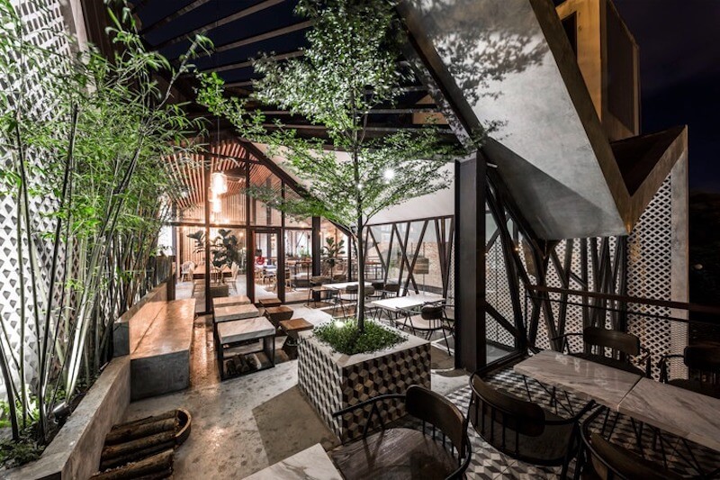 Không gian cafe mang phong cách Industrial và Tropical sang trọng với lối thiết kế mở, cây xanh được bố trí khéo léo như điểm nhấn giữa kiến trúc bê tông