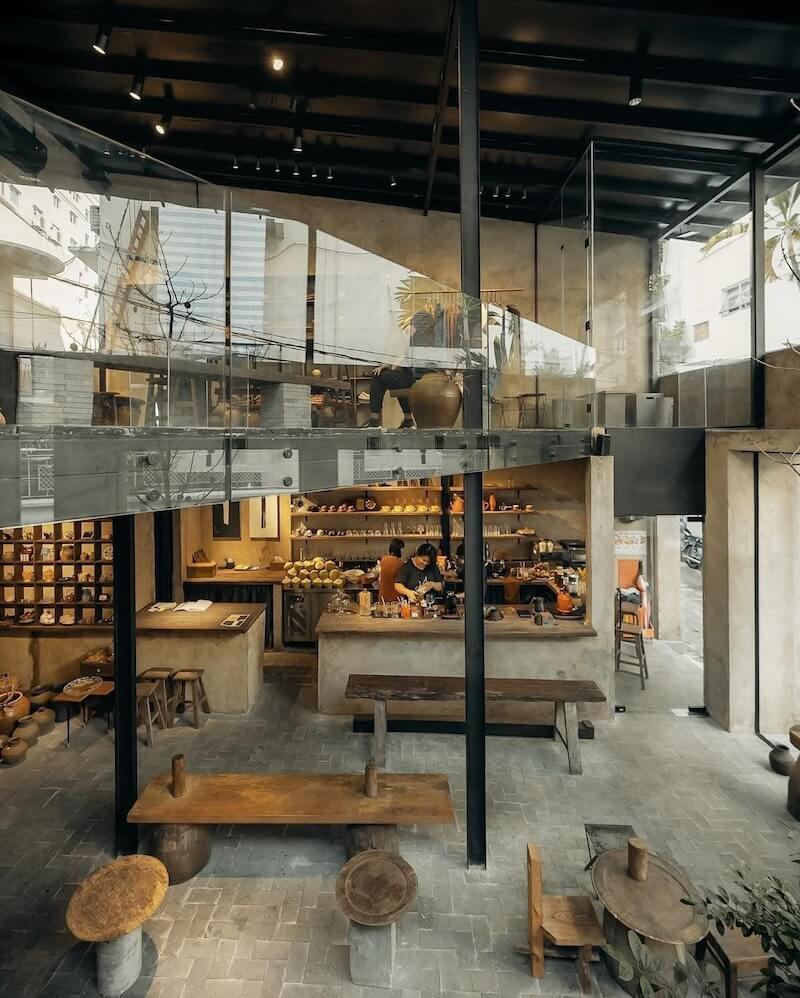 Thiết kế quán cafe concept nhà máy tái hiện không gian công nghiệp với trần cao, khung thép và vật liệu thô mộc
