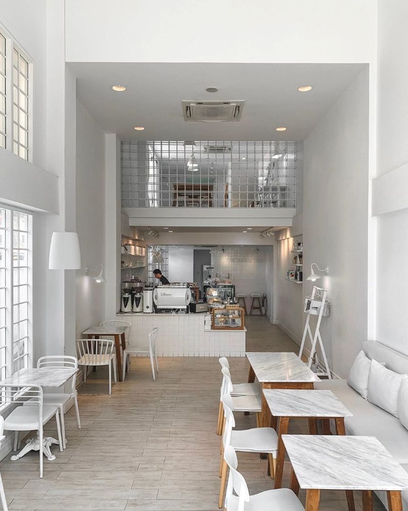 Thiết kế quán cafe có gác lửng tối giản với tone trắng chủ đạo, tận dụng ánh sáng tự nhiên từ các ô cửa sổ mang đến không gian thoải mái