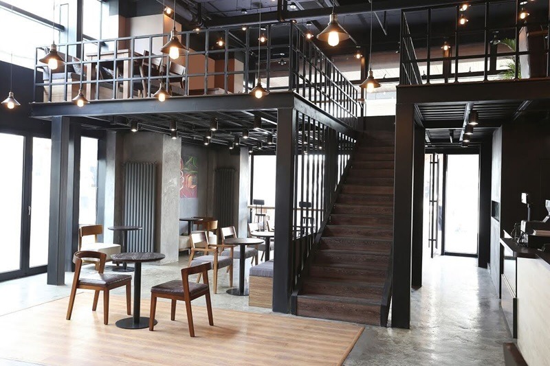Cầu thang dẫn lên gác lửng được đặt khéo léo bên hông quán, giúp tiết kiệm diện tích và tối ưu lối đi