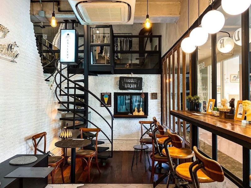 Không gian quán cafe gác lửng phong cách Scandinavian nổi bật với thiết kế tường gạch trắng kết hợp nội thất gỗ tự nhiên