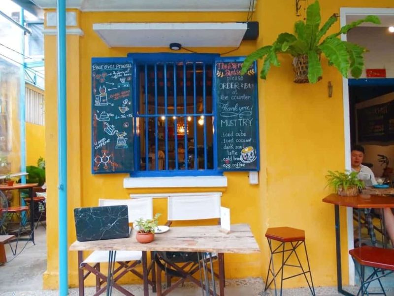 Quán cafe phong cách Hội An với tone vàng mù tạt chủ đạo, kết hợp đèn lồng và gỗ mộc, mang lại không gian hoài cổ ấm áp, gợi nhớ ký ức phố cổ