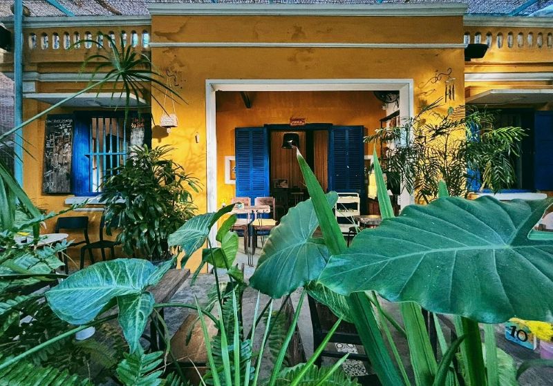 Quán cafe phong cách Hội An với kiến trúc cổ, cửa gỗ mộc mạc tạo không gian gần gũi, giữ trọn hồn phố cổ và mang lại trải nghiệm hoài niệm độc đáo cho khách hàng