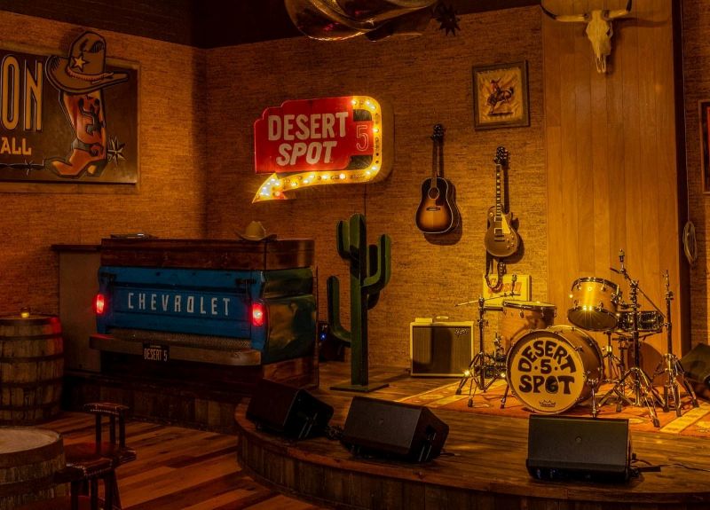 Quán cà phê karaoke gây ấn tượng với sân khấu lộng lẫy, rèm nhung đỏ thẫm, đèn chùm sang trọng và bộ sofa da êm ái, tạo không gian giải trí đẳng cấp