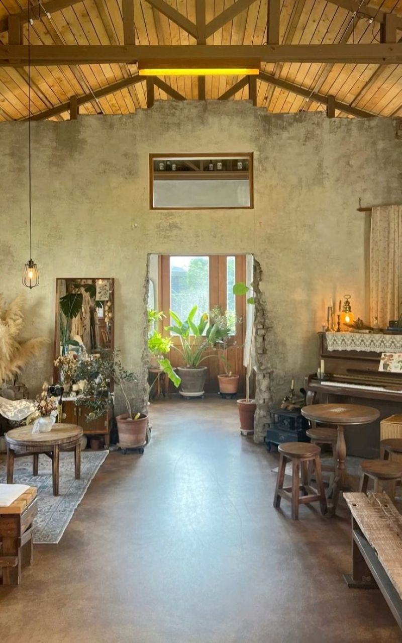 Thiết kế quán cafe ở nông thôn phong cách Industrial tận dụng ánh sáng tự nhiên từ các ô cửa kính lớn, làm nổi bật những mảng tường xi măng trần