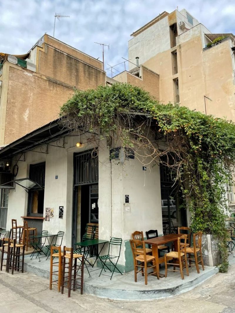 Quán cafe này mang đậm phong cách mộc mạc đô thị: một góc nhà cũ với tường loang lổ, bàn ghế gỗ giản dị, mái hiên phủ dây leo xanh mướt, tạo cảm giác gần gũi và thân thuộc