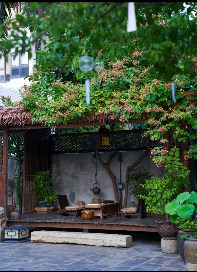 Quán trà đạo mang phong cách tối giản Á Đông đượm vẻ cổ kính với sàn gỗ tự nhiên, mái tranh che xanh hoa lá, tạo không gian bình yên, mộc mạc và gần gũi với nghi lễ trà