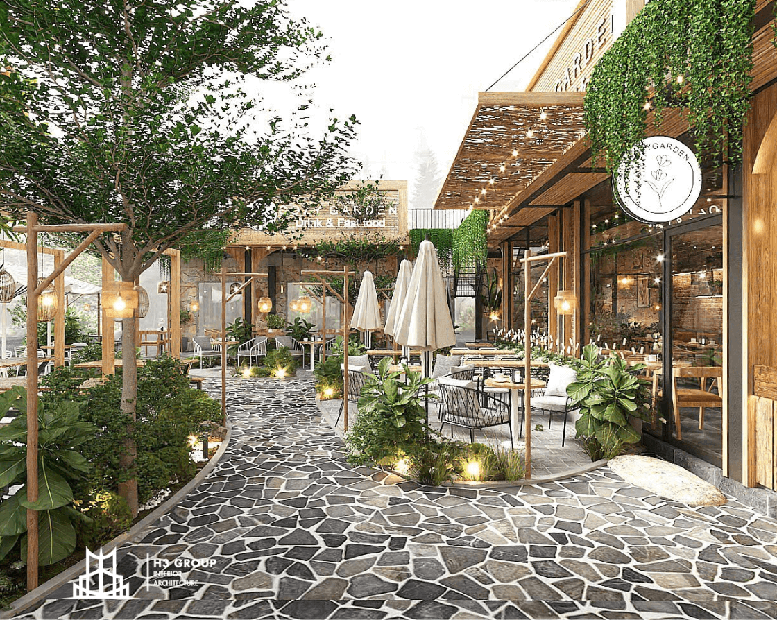 Thiết kế quán cafe theo phong cách Đà Lạt với không gian sân vườn lãng mạn, bàn ghế gỗ mộc, cây xanh và đèn ấm áp, tạo cảm giác gần gũi với thiên nhiên và thư thái