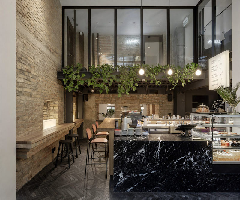 Ánh sáng tự nhiên được tận dụng triệt để, kết hợp với đèn công nghiệp tối giản, mang đến bầu không khí sáng và rộng rãi