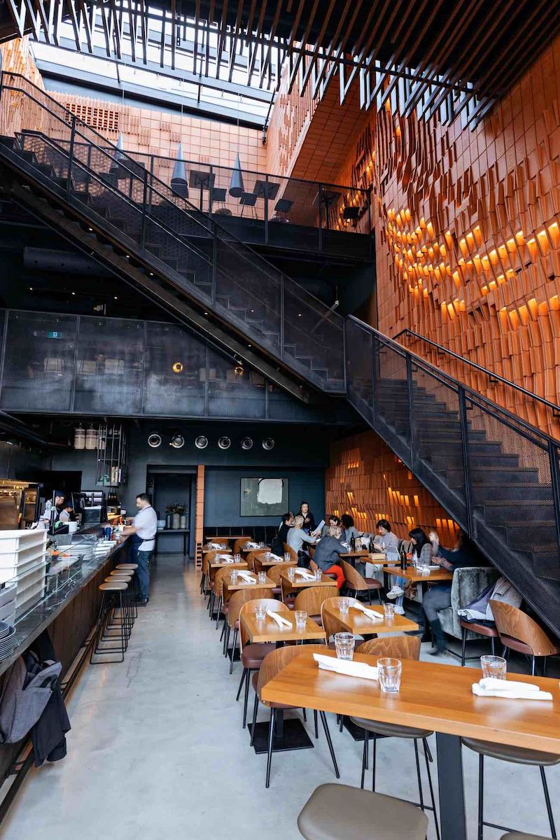 Thiết kế nhà hàng khung thép phong cách Industrial tận dụng không gian mở lớn, kết hợp trần cao và vật liệu thô mộc để mang đến cảm giác mạnh mẽ và hiện đại 