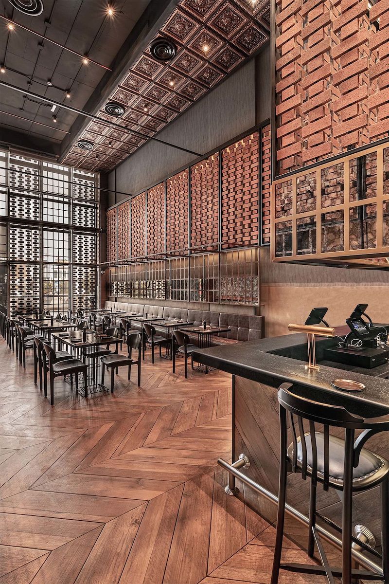 Các chi tiết trang trí như ống dẫn lộ thiên, dầm thép và trần bê tông được giữ nguyên trong thiết kế nhà hàng khung thép phong cách Industrial để tạo điểm nhấn