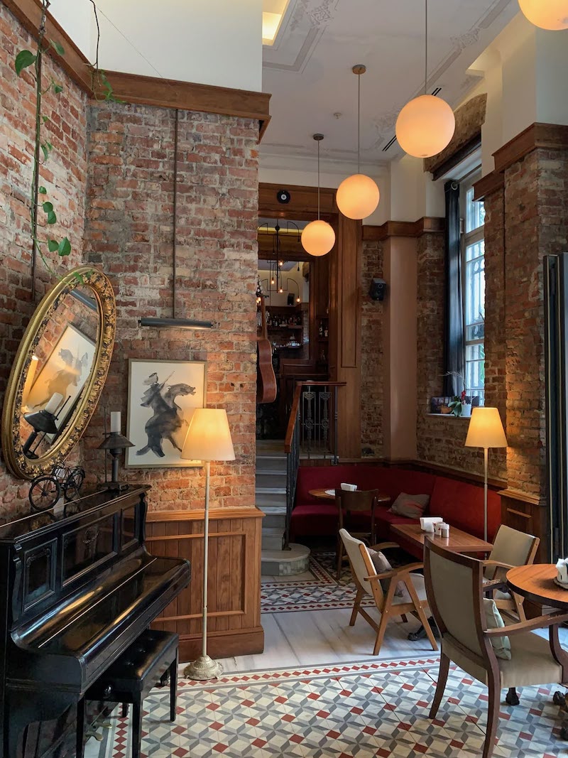 Thiết kế nội thất nhà hàng Vintage cổ điển sử dụng tranh cổ điển, gương và đèn treo độc đáo để tăng trải nghiệm thị giác