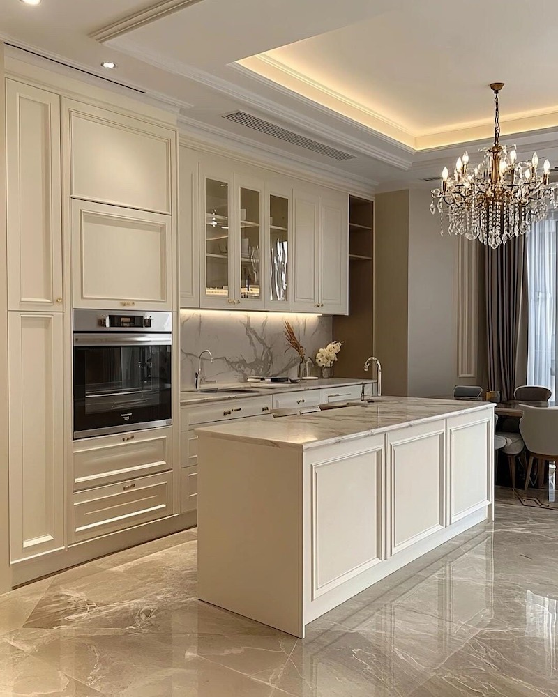 Khu bếp phong cách Tân cổ điển sử dụng tủ bếp gỗ cao cấp kết hợp đá Marble, tạo vẻ sang trọng và tiện nghi cho căn hộ 80m2